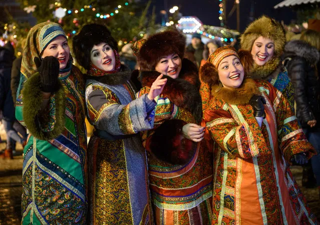 Women in traditional costumes entertain the visitors at the Christmas market on the Red Square in Moscow, Russia on December 2, 2018. (Photo by Mladen Antonov/AFP Photo)