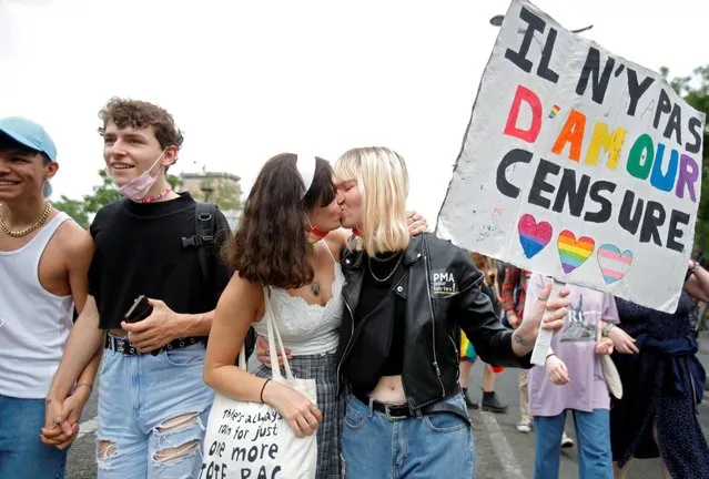 Participants holding a placard kiss during the traditional LGBTQ Pride march in Paris, France on June 26, 2021. The placard reads, “There is no love censorship”. (Photo by Sarah Meyssonnier/Reuters)