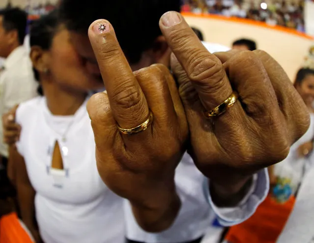 A Filipino couple display their wedding rings during a mass wedding in Manila, Philippines, 12 February 2016. About 350 Filipino couples participated in a civil mass wedding two days before Valentine's Day officiated by former president and current Manila mayor Joseph Estrada to strengthen family ties. (Photo by Francis R. Malasig/EPA)