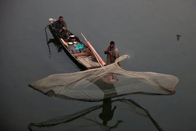 A fisherman casts his net in the waters of a flood channel on the outskirts of Srinagar, January 1, 2017. (Photo by Danish Ismail/Reuters)