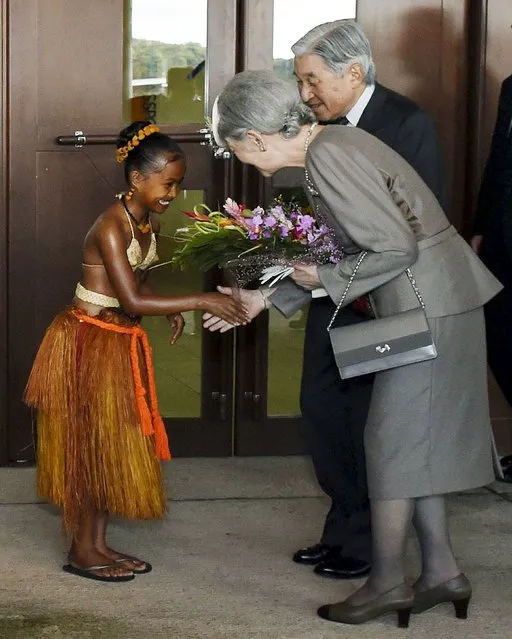 Japan's Emperor Akihito (R) and Empress Michiko (front, R) receive flowers from a local girl upon their arrival at Palau international airport in Airai on Palau's  Babelthuap Island, in this photo released by Kyodo April 8, 2015. Emperor Akihito arrived the island nation of Palau on Wednesday where he will visit a World War Two battlefield, the latest journey in his efforts to soothe the wounds of a conflict that haunts Asia 70 years after its end. (Photo by Reuters/Kyodo News)