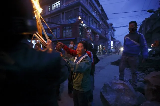 A protester lights a torch as he takes part during the torch rally in Kathmandu April 6, 2015. (Photo by Navesh Chitrakar/Reuters)