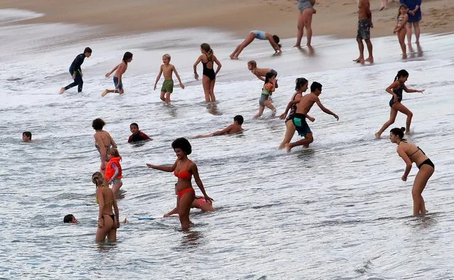 People enjoy the sea at Atlantic Ocean in Biarritz, southwestern France, Wednesday, October 26, 2022. Temperatures in southwestern France have mounted all week and were expected to hit over 30° Celcius (86° Farhenheit). (Photo by Bob Edme/AP Photo)