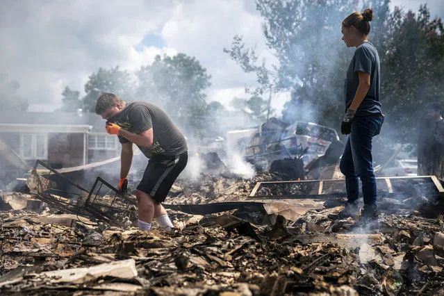 Josh Whitlock and Stacy Mathieson look through what is left of their home after it burned following flooding in Waverly, Tenn., Sunday, August 22, 2021. (Photo by Andrew Nelles/The Tennessean via AP Photo)