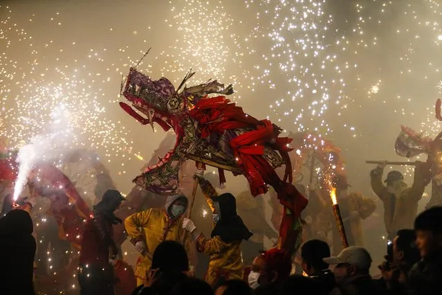 This photo taken on February 16, 2019 shows people watching a dragon dance to celebrate the upcoming Lantern Festival in Yuqing county in Zunyi in China's southwestern Guizhou province. The annual Lantern Festival will be marked on February 19, which is the 15th day of the Lunar New Year. (Photo by AFP Photo/China Stringer Network)