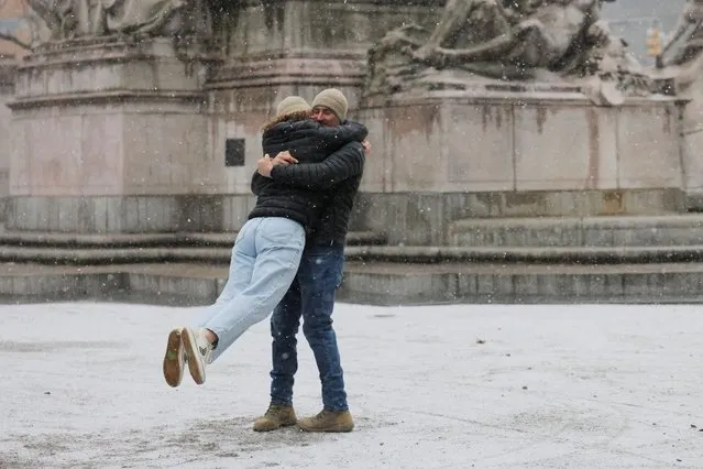 Two people embrace as snow falls in New York City on January 6, 2024. (Photo by Andrew Kelly/Reuters)