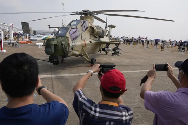 Visitors take photos of a Chinese military attack helicopter displayed during 13th China International Aviation and Aerospace Exhibition on Wednesday, September 29, 2021, in Zhuhai in southern China's Guangdong province. (Photo by Ng Han Guan/AP Photo)
