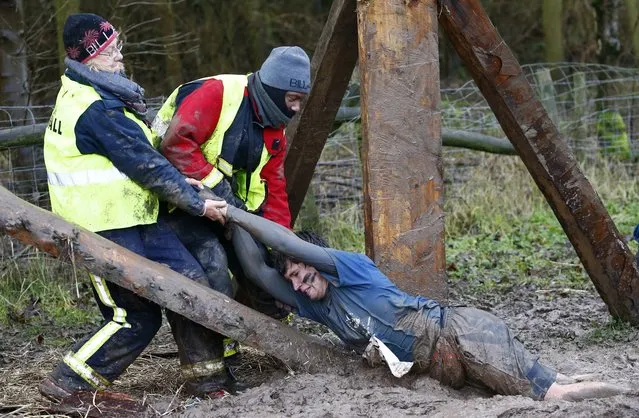 A competitor is dragged out of the mud during the Tough Guy event in Perton, central England, January 26, 2014. (Photo by Darren Staples/Reuters)