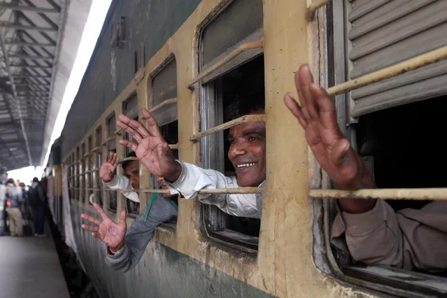 Fishermen from India who were held captive for crossing territorial waters wave from the windows of a train after their release, at Cantonment railway station in Karachi, Pakistan, January 5, 2017. (Photo by Akhtar Soomro/Reuters)