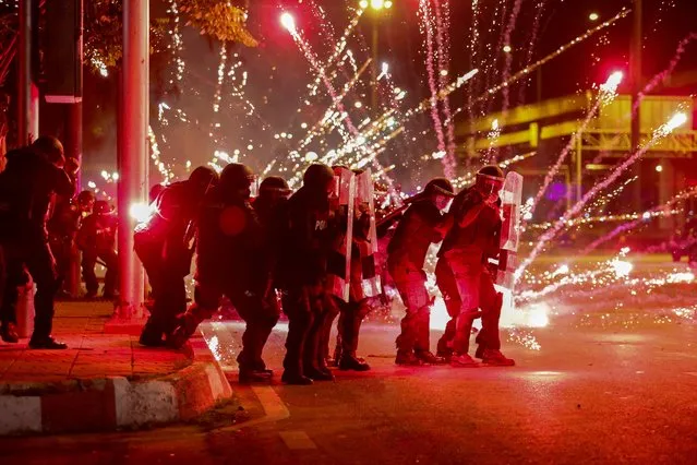 Fireworks launched by protesters explode in front of riot police during a demonstration calling for the resignation of Thailand's Prime Minister Prayut Chan-O-Cha over the government's handling of the Covid-19 coronavirus crisis in Bangkok on September 12, 2021. (Photo by Krit Phromsakla Na Sakolnakorn/Reuters)
