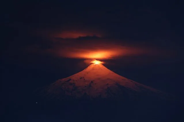 The Villarrica volcano is seen at night from Villarrica town, Chile on December 20, 2023. (Photo by Cristobal Saavedra Escobar/Reuters)