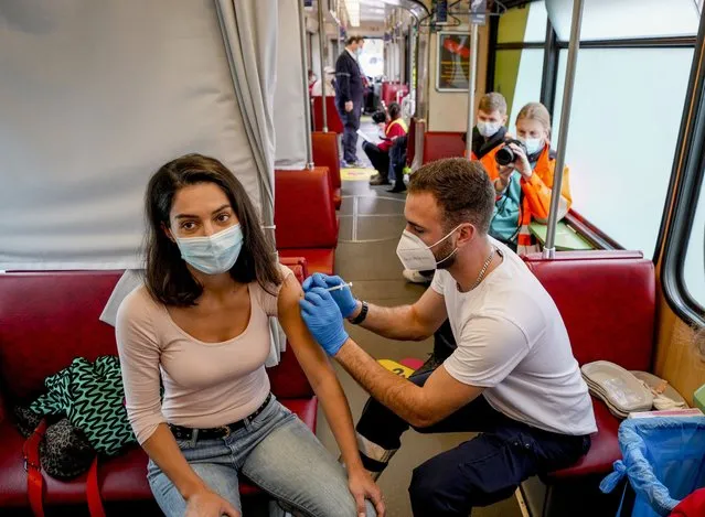 A woman receives her first vaccination in the so called “vaccination express” tram in central Frankfurt, Thursday, November 4, 2021. About 100 people are vaccinated every day in two trams. (Photo by Michael Probst/AP Photo)