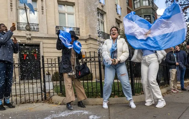 Celebrations at the Petra Hoke, center, of DC, shakes up a bottle of champagne outside the Argentinian Embassy after the world cup final, in Washington, DC. on December 21, 2022. (Photo by Bill O'Leary/The Washington Post)