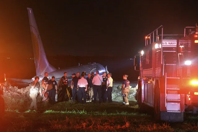 This Friday, May 3, 2019 photo provided by the U.S. Navy shows emergency crews working next to a Boeing 737 aircraft arriving from Naval Station Guantanamo Bay, Cuba, which slid off the runway at Naval Air Station Jacksonville, Fla., into the St. Johns River. It was carrying 136 passengers and seven crew. Authorities said everyone on board emerged without critical injuries. (Photo by Thomas A. Higgins/U.S. Navy via AP Photo)