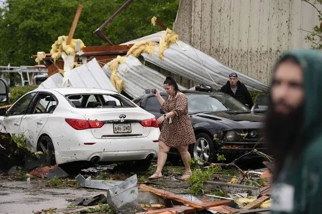 Robin Marquez, project coordinator for E.C.O. Builders, walks past her son's heavily damaged car after they sheltered in place inside the business, for what she said was a tornado, in the aftermath of severe storms that swept through the region in Slidell, La., Wednesday, April 10, 2024. (Photo by Gerald Herbert/AP Photo)
