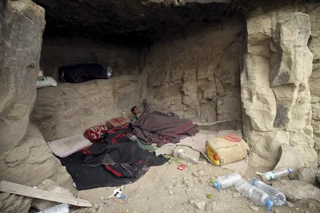 A youth sleeps in a cave after his home was destroyed during an air strike carried out by the Saudi-led coalition in Faj Attan village, Sanaa, Yemen May 7, 2015. (Photo by Mohamed al-Sayaghi/Reuters)