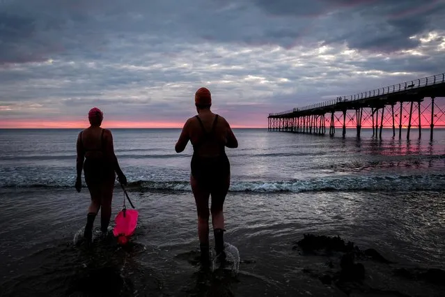 Two women head into the North sea for a swim on the morning of the summer solstice at Saltburn beach on June 21, 2019 in Saltburn-by-the-Sea, England. The summer solstice is the point in the year when Earth’s North Pole tilts furthest towards the sun. The solstice is the longest day of the year in the northern hemisphere with the most hours of daylight. There will be 16 hours and 38 minutes of daylight in the UK. (Photo by Ian Forsyth/Getty Images)