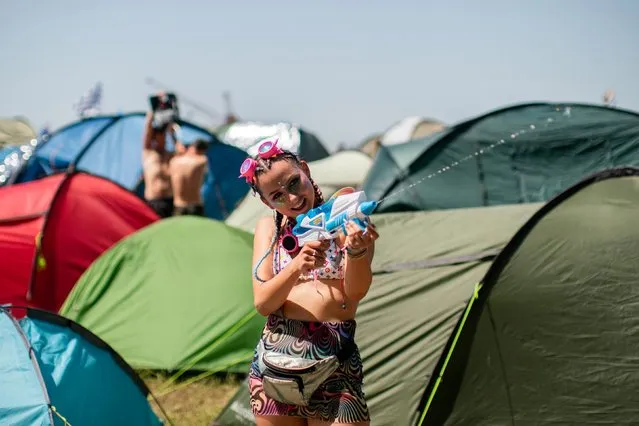 A girl fires a water pistol to cool off on the festival's second day at Glastonbury Festival in Pilton, Britain, 27 June 2019. (Photo by South West News Service)