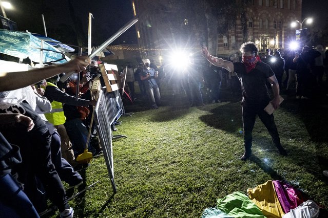 Counter protesters attack a pro-Palestinian encampment set up on the campus of the University of California Los Angeles (UCLA) as clashes erupt, in Los Angeles on May 1, 2024. Clashes broke out on May 1, 2024 around pro-Palestinian demonstrations at the University of California, Los Angeles, as universities around the United States struggle to contain similar protests on dozens of campuses. (Photo by Etienne Laurent/AFP Photo)