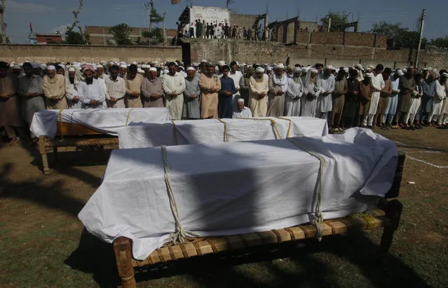 People offer funeral prayers of Pakistani villagers killed as a roof of their house caved in due to heavy rains, in Charsadda, Pakistan, Thursday, April 18, 2019. (Photo by Muhammad Sajjad/AP Photo)