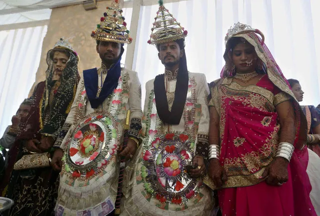 Pakistani brides and grooms pose for photograph during a mass wedding ceremony in Karachi, Pakistan, Sunday, January 9, 2022. The Pakistan Hindu Council organized a mass marriage ceremony for 76 couples who could not afford their individual wedding expenses. (Photo by Fareed Khan/AP Photo)
