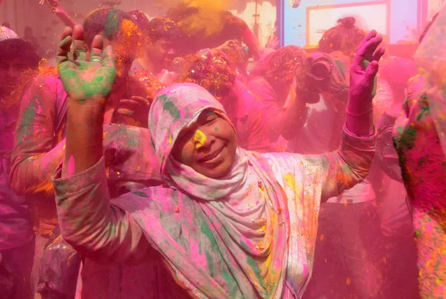 An Indian widow dances during celebrations for Holi or “festival of colors” in Vrindavan on March 9, 2017. Widows congregated on a small patio of the Govinath temple in which they live and danced and played with colored powder to celebrate the occasion. (Photo by Dominique Faget/AFP Photo)