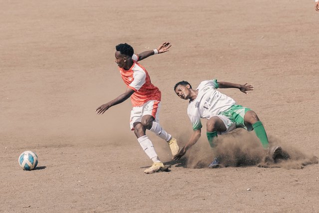 Mekelle 70 Enderta's midfielder Yohannes Tsegay, 24, (C) fights for the ball with a Raya Azebo's defender during a match at the Mekelle Football Stadium in Mekele, on May 25, 2024. The Ethiopian Football Federation has announced the return of the football clubs from Tigray to the Ethiopian Premier League after a two-year war between Ethiopia's government and Tigrayan rebel authorities tore the northern region apart before a November 2022 peace deal. The three Tigray-based teams, Mekelle 70 Enderta, Shire Endaselassie, and Welwalo Adigrat University, which were prominent in the league before the outbreak of the conflict, are now set to resume their positions. (Photo by Amanuel Sileshi/AFP Photo)