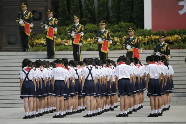 Students stand in silent tribute outside the Museum of the War of Chinese People's Resistance Against Japanese Aggression, near the Marco Polo Bridge on the outskirts of Beijing, July 7, 2015. With dioramas of heroic Communist soldiers and graphic pictures of massacres, China formally kicked off its commemorations for the 70th anniversary of the end of World War Two on Tuesday with the unveiling of a new exhibition. (Photo by Jason Lee/Reuters)