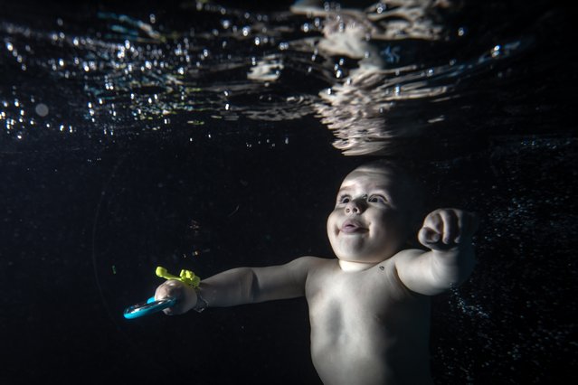 A baby, receiving swimming and diving training, is seen underwater in Istanbul, Turkiye on June 6, 2024. In addition to those with normal development, babies with various muscle disorders are given swimming and diving lessons starting at two months old. These lessons, believed to benefit babies' perceptual abilities, intelligence, balance, and coordination, aim to accelerate their development. (Photo by Sebnem Coskun/Anadolu via Getty Images)