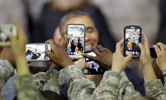 U.S. military soldiers using their smartphones take pictures of U.S. President Barack Obama after delivering a speech at U.S. military base Yongsan Garrison in Seoul, South Korea, Saturday, April 26, 2014. (Photo by Lee Jin-man/AP Photo)