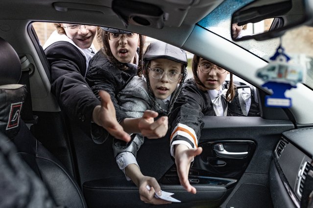 A group of Orthodox Jewish boys gather around a car to try and collect tokens during the Jewish holiday of Purim  on March 07, 2023 in London, England. Purim 2023 begins on Monday night, March 6 and continues through Tuesday, March 7. It commemorates the salvation of the Jewish people in the ancient Persian empire from Haman's plot. (Photo by Dan Kitwood/Getty Images)