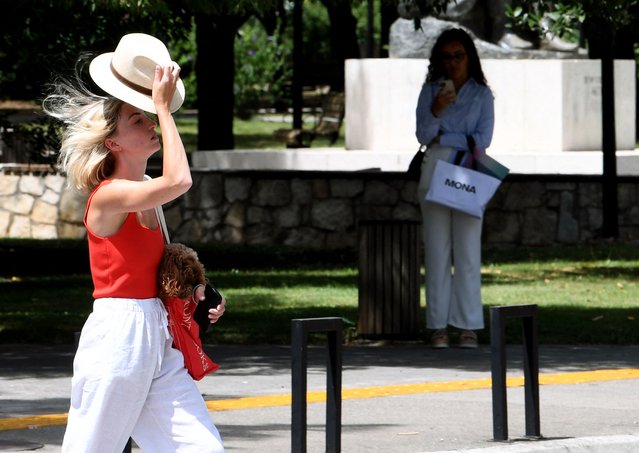 A pedestrian with a hat walks in the streets of Podgorica, on June 21, 2024, as temperatures reach 42 degrees Celsius in the first heatwave of this season. (Photo by Savo Prelevic/AFP Photo)