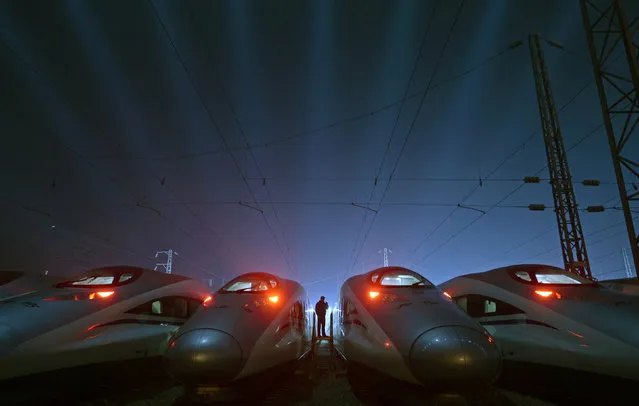 A worker stands among Harmony bullet trains at a high-speed train maintenance base in Wuhan, Hubei province Friday, March 13, 2015. (Photo by Reuters/Stringer)