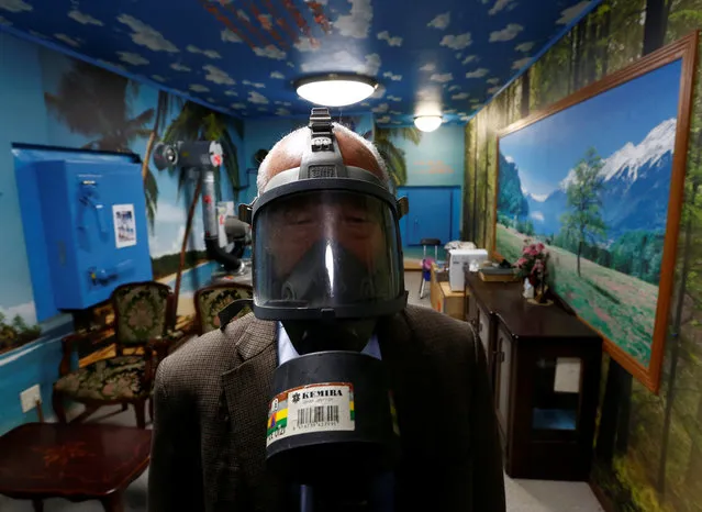Seiichiro Nishimoto, CEO of Shelter Co., poses wearing a gas mask at a model room for the company's nuclear shelters in the basement of his house in Osaka, Japan on April 26, 2017. (Photo by Kim Kyung-Hoon/Reuters)