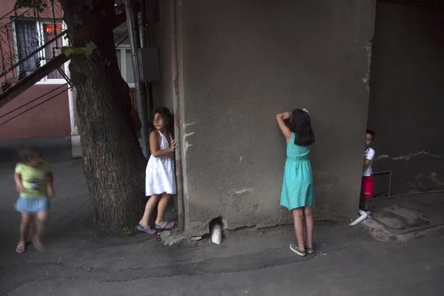 In this Saturday, July 11, 2015 photo, children play hide and seek in Tbilisi, Georgia. (Photo by Tinatin Kiguradze/AP Photo)