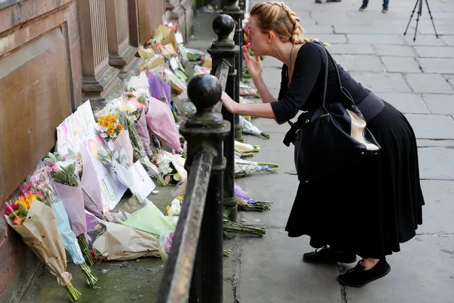 A woman blows a kiss after laying flowers for the victims of the Manchester Arena attack, in central Manchester, Britain May 23, 2017. (Photo by Darren Staples/Reuters)