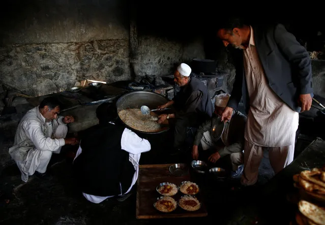 A cook (C) prepares lunch to be distributed to workers at the Jabal Saraj cement factory in Jabal Saraj, north of Kabul, Afghanistan May 8, 2016. (Photo by Ahmad Masood/Reuters)