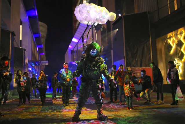 A man wearing an illuminated atmospheric diving suit as part of an installation titled “What Lies Beneath” looks at members of the public during the Vivid Sydney festival of light and sound in Sydney, Australia, May 26, 2017. (Photo by Steven Saphore/Reuters)