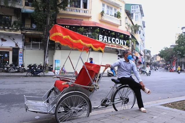 A rickshaw puller waits for customers in the old quarter of Hanoi, Vietnam on Wednesday, March 16, 2022. (Photo by Hau Dinh/AP Photo)