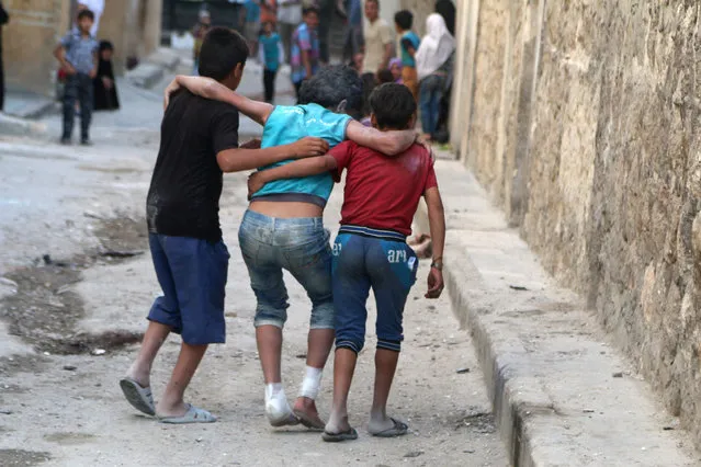Boys help their injured friend after an airstrike on Aleppo's rebel held al-Fardous district, Syria June 2, 2016. (Photo by Abdalrhman Ismail/Reuters)
