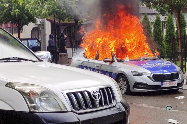 In this image made from video, Kosovar police car burns in Zvecan, northern Kosovo Friday, May 26, 2023. Serbia put its troops on the border with Kosovo on the highest state of alert Friday following clashes between ethnic Serbs and Kosovo police that left more than a dozen injured on both sides. (Photo by AP Photo)