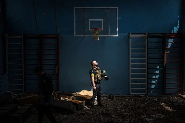 A Ukrainian policeman stands inside a school sport hall, where, according to residents, Russian soldiers were based in the village of Vilkhivka, after it was retaken by Ukrainian Army, near the eastern city of Kharkiv on May 13, 2022, on the 79th day of the Russian invasion of Ukraine. Pentagon chief called for “immediate” ceasefire in Ukraine in call with Russian counterpart on May 13, 2022. (Photo by Dimitar Dilkoff/AFP Photo)