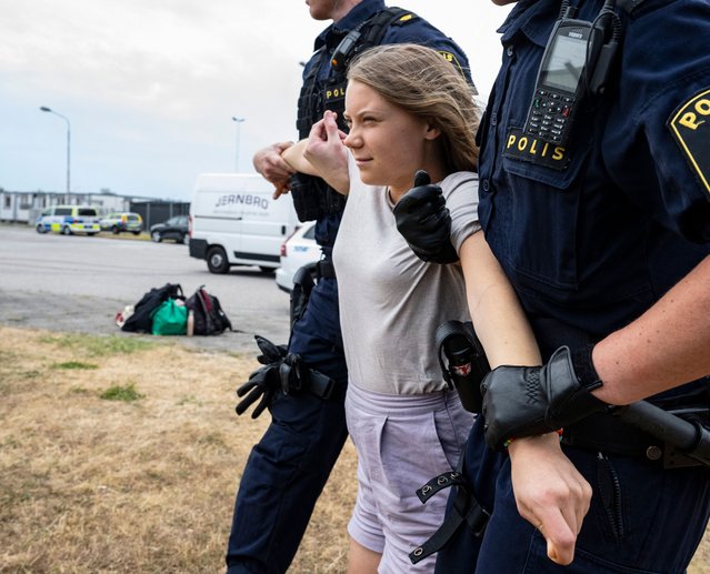 Police officers carry Swedish climate activist Greta Thunberg away together with other climate activists from the organization “Ta Tillbaka Framtiden” (Take Back the Future), who block the entrance to Oljehamnen neighbourhood in Malmo, Sweden, on June 19, 2023, for the 5th day in a row. (Photo by Johan Nilsson/TT News Agency via AFP Photo)