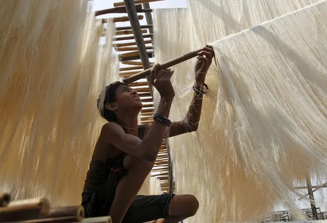 A boy hangs strands of vermicelli, a specialty eaten during the Muslim holy fasting month of Ramadan, to dry at a factory in Allahabad, India, June 7, 2016. (Photo by Jitendra Prakash/Reuters)