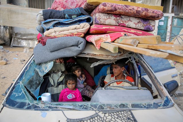 Displaced Palestinians sit in a damaged car as they flee areas in the eastern part of Khan Younis following an Israeli evacuation order in Khan Younis in the southern Gaza Strip on October 7, 2024. (Photo by Hatem Khaled/Reuters)