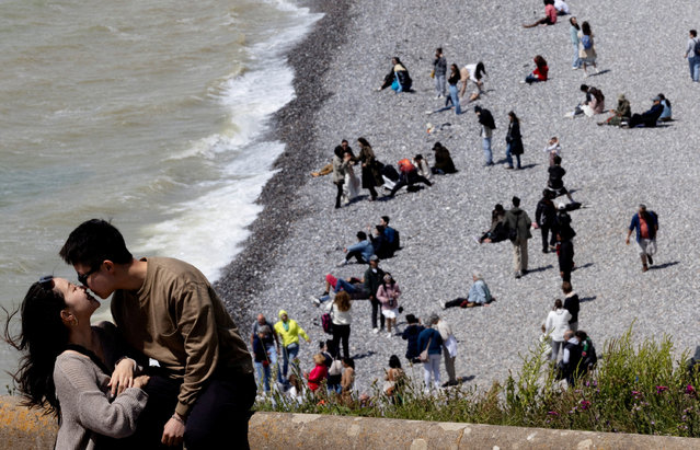 A couple kisses as people enjoy the weather at the Seven Sisters Cliffs, at Birling Gap in East Sussex county, Britain on June 9, 2024. (Photo by Carlos Jasso/Reuters)