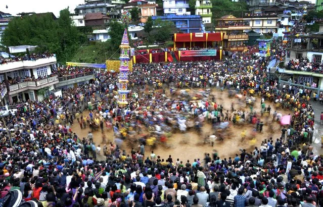 Indian Jaintia tribesmen pull a chariot during celebrations for the Behdienkhlam festival in Jowai, some 64 kms from Shillong, on July 16, 2014. Behdienkhlam is a traditional festival celebrated after farmers plant their crops, seeking a good harvest. Prayers are also offered to drive away plague and other diseases. (Photo by Biju Boro/AFP Photo)