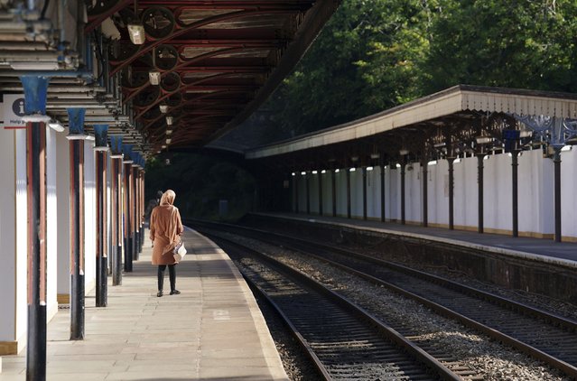 A passenger waits at Great Malvern train station as members of the Rail, Maritime and Transport union begin their nationwide strike, in Worcester, England, Tuesday June 21, 2022. Tens of thousands of railway workers walked off the job in Britain on Tuesday, bringing services grinding to a halt in the country’s biggest transit strike in three decades. (Photo by David Davies/PA Wire via AP Photo)