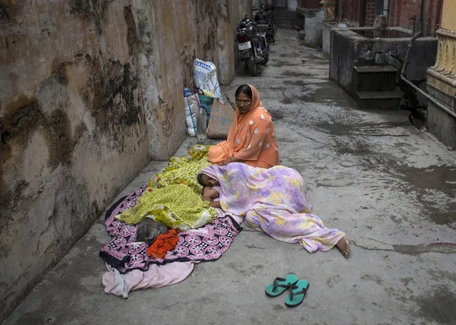 Devki Rai, 49, lies next to the body of her mother Champa Devi, minutes after her death at the Mukti Bhavan (Salvation House) in Varanasi, in the northern Indian state of Uttar Pradesh, June 21, 2014. (Photo by Danish Siddiqui/Reuters)