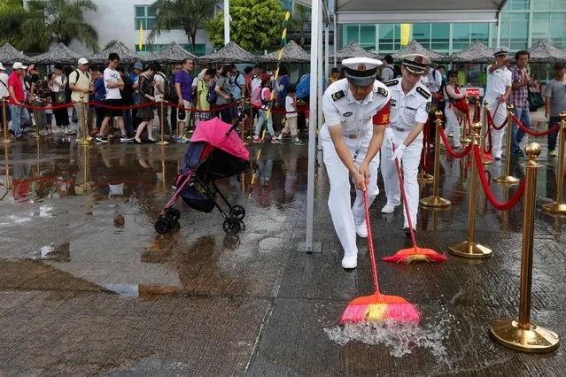 People's Liberation Army naval soldiers sweep water away after rain at a naval base during an open day celebrating the 19th anniversary of Hong Kong's handover to Chinese sovereignty from British rule, in Hong Kong July 1, 2016. (Photo by Bobby Yip/Reuters)